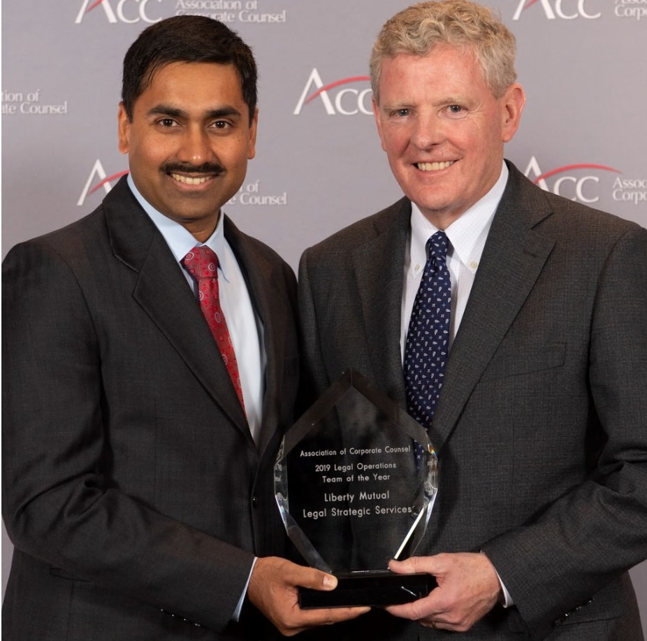 Personnel smiling and holding award