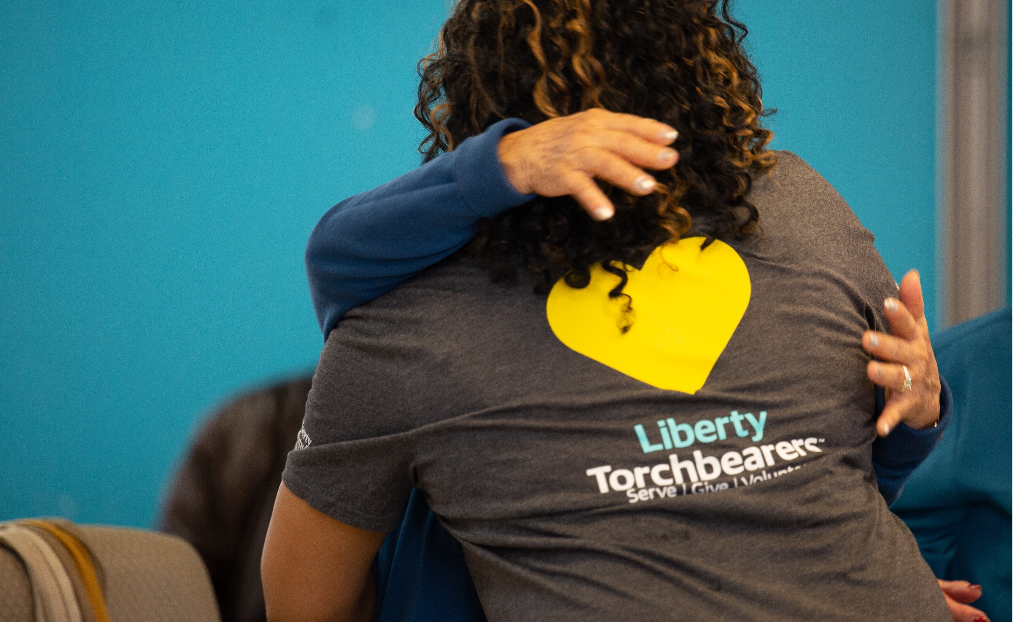 Two individuals at Serve with Liberty embracing