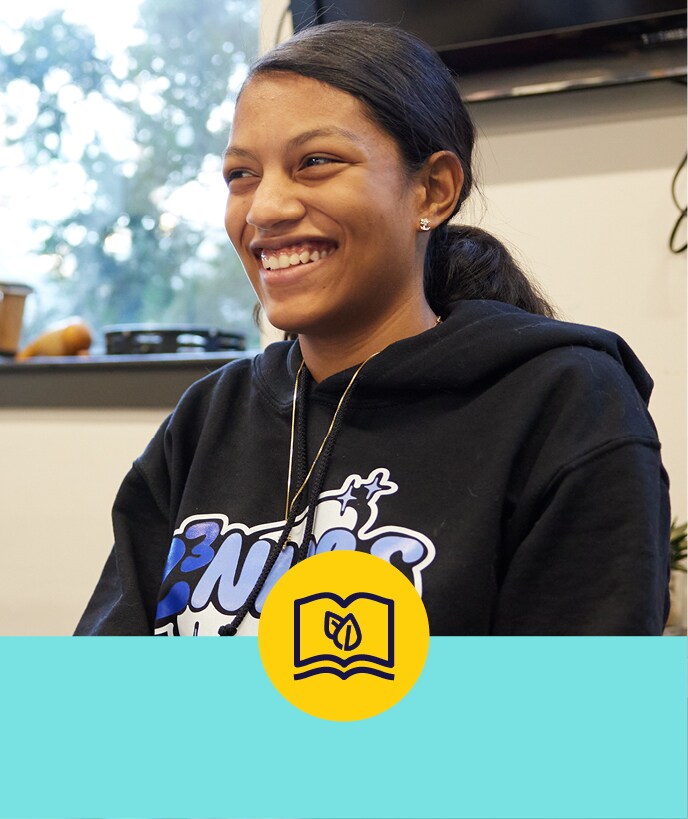 Teenager in a classroom, smiling off camera