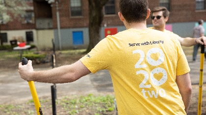 Liberty employee wearing a Serve with Liberty shirt, while volunteering
