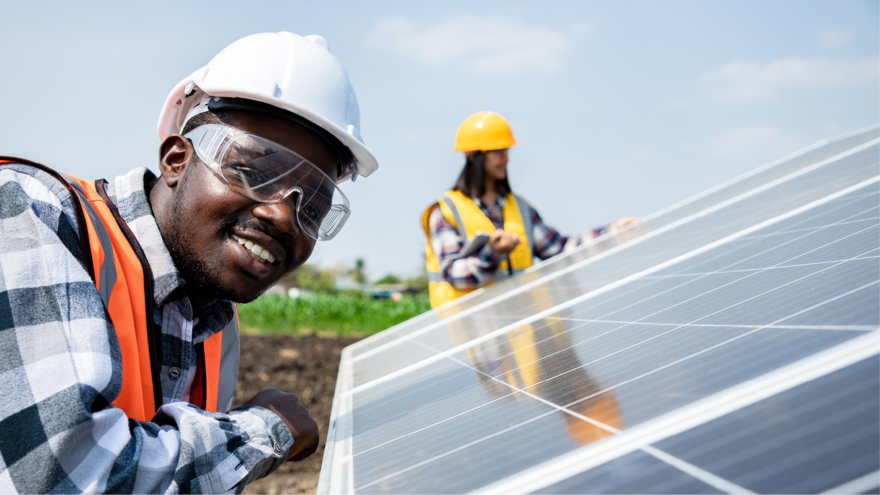 Two men outdoors working on a solar panel