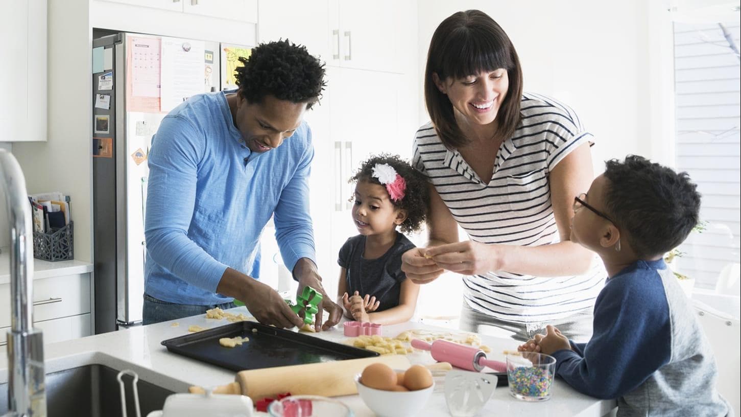 Family of four in the kitchen cooking breakfast