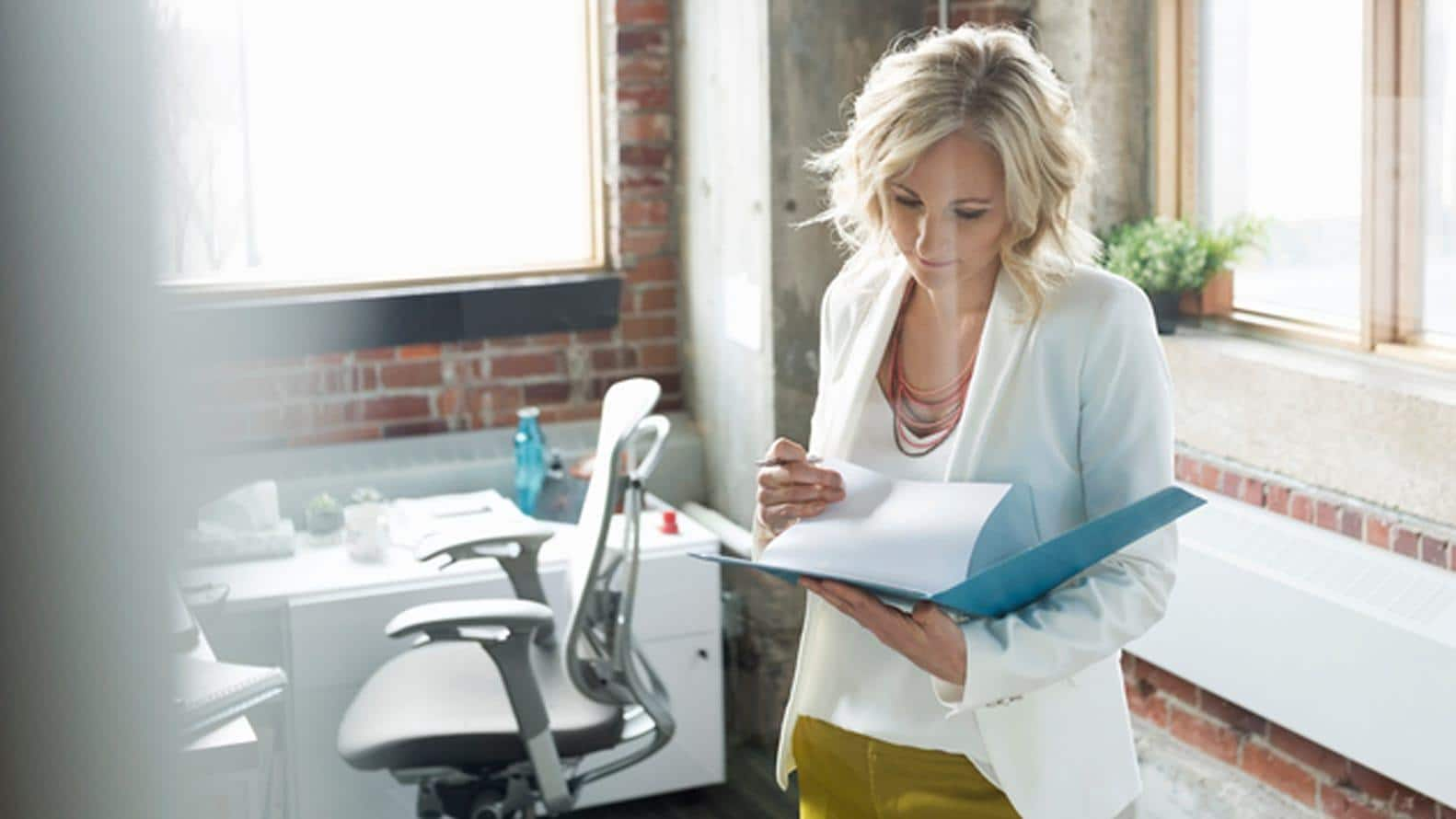 Woman looking through papers in a folder in an office space