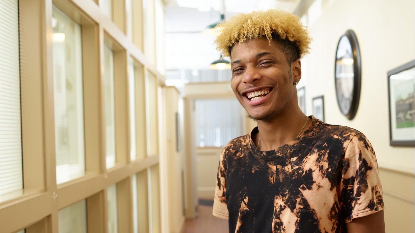 (slide 6 of 7) Image of a teen smiling into camera . 