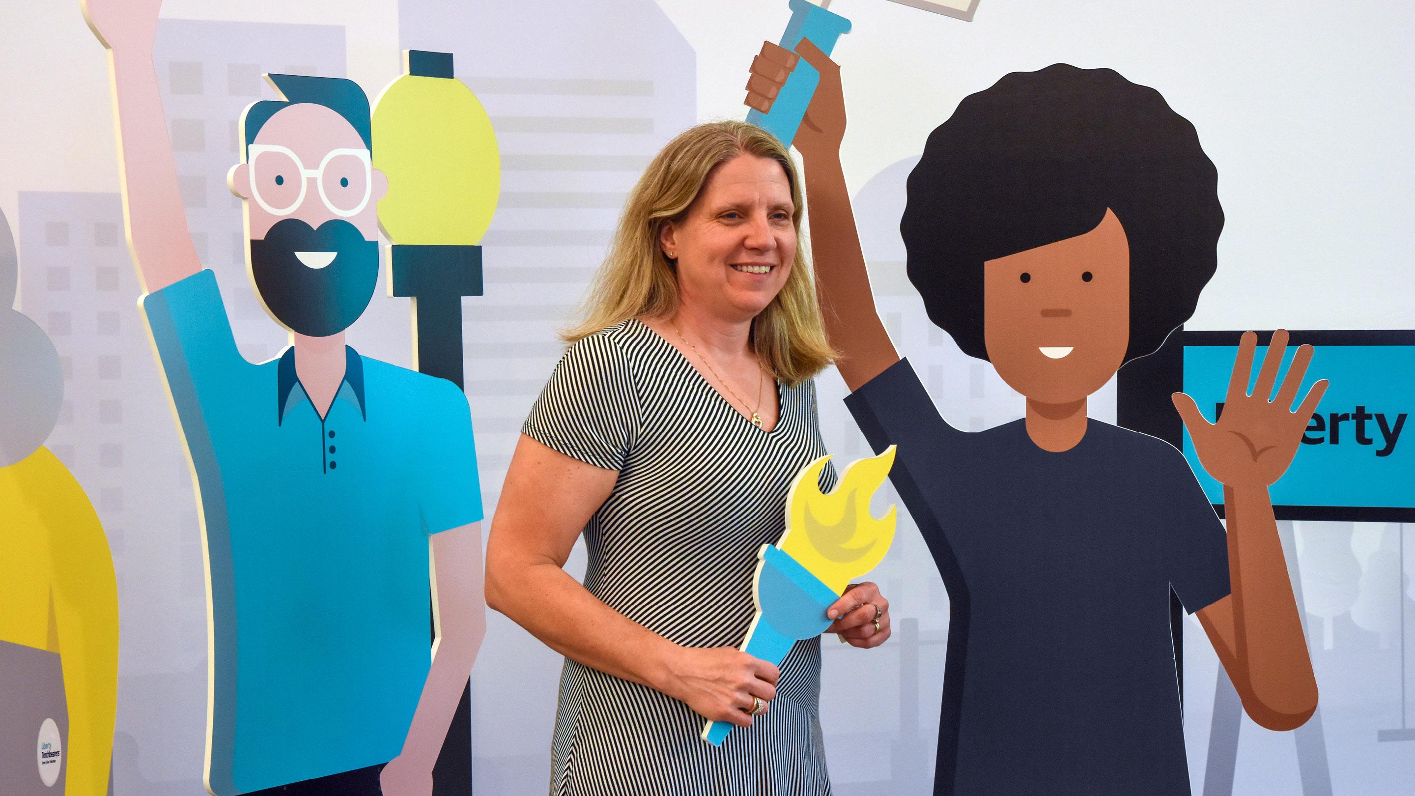 (slide 2 of 4) Liberty employee posing with cardboard torch. 