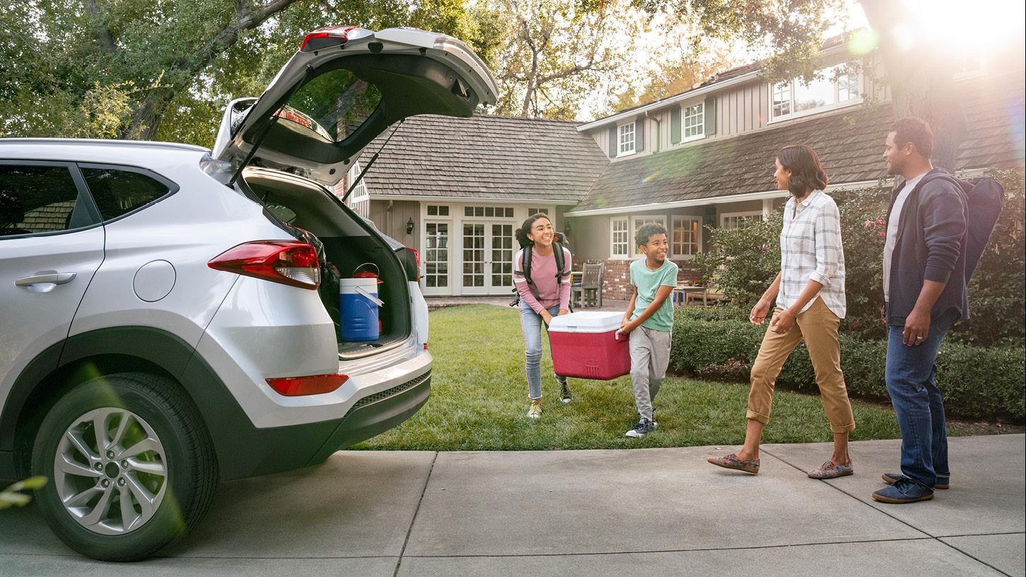 diverse family loading the car for a trip