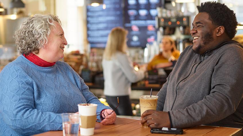 A woman and teen, having coffee and chatting