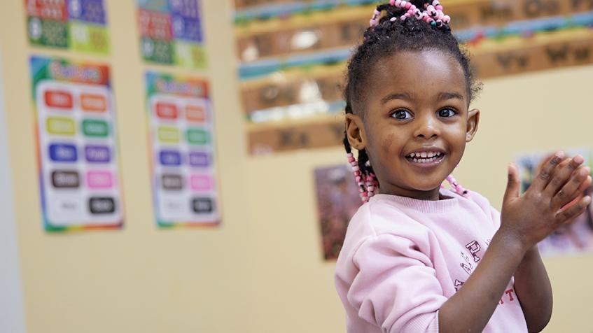 Toddler playing and smiling to camera