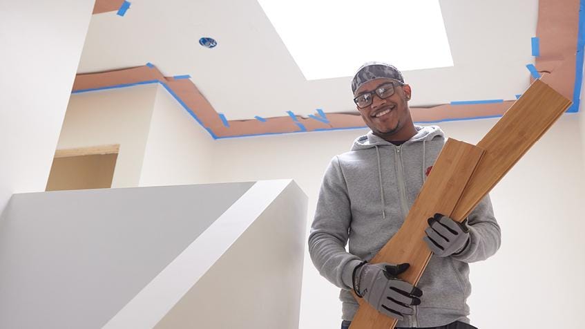 Teenager holding ply wood and smiling to camera 