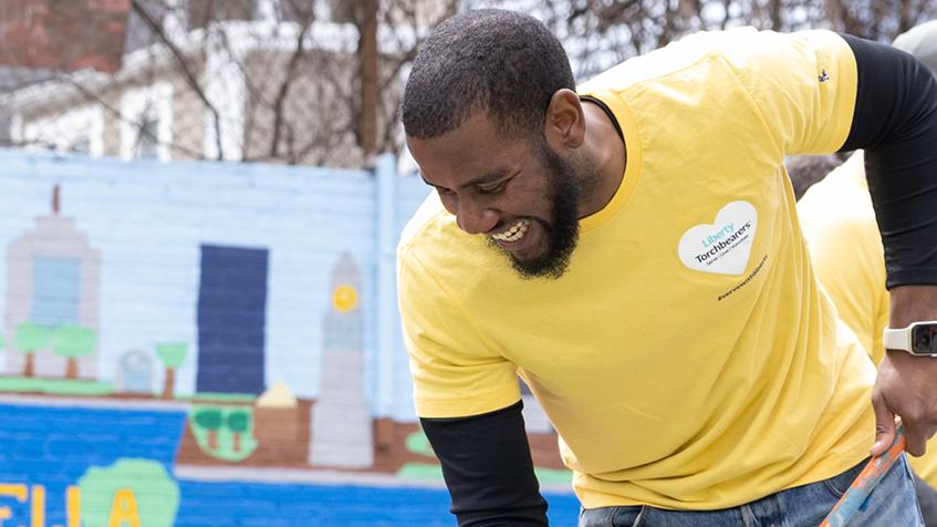 Liberty Mutual employee volunteering and shoveling outside 