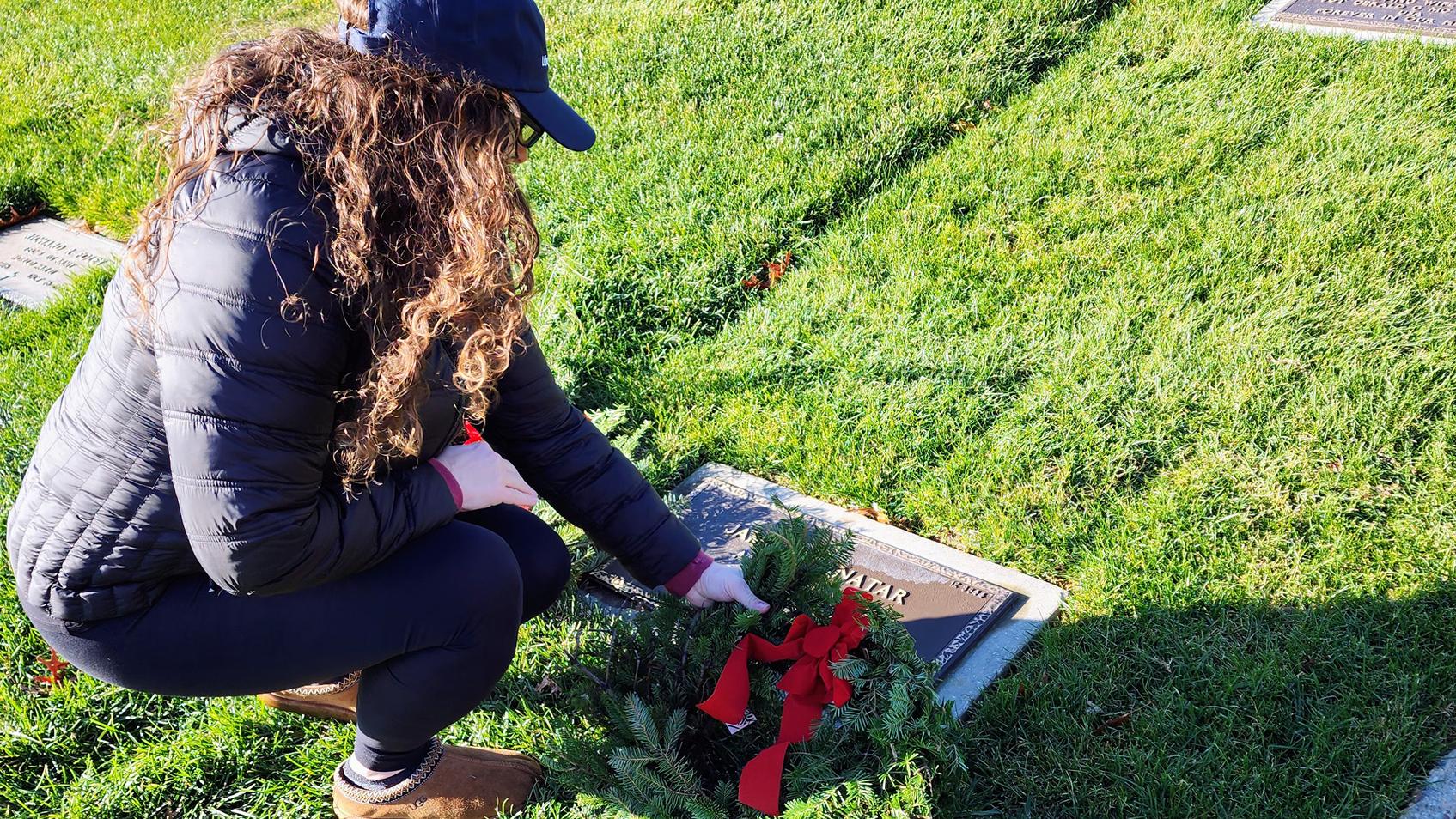 Woman placing a wreath on a memorial