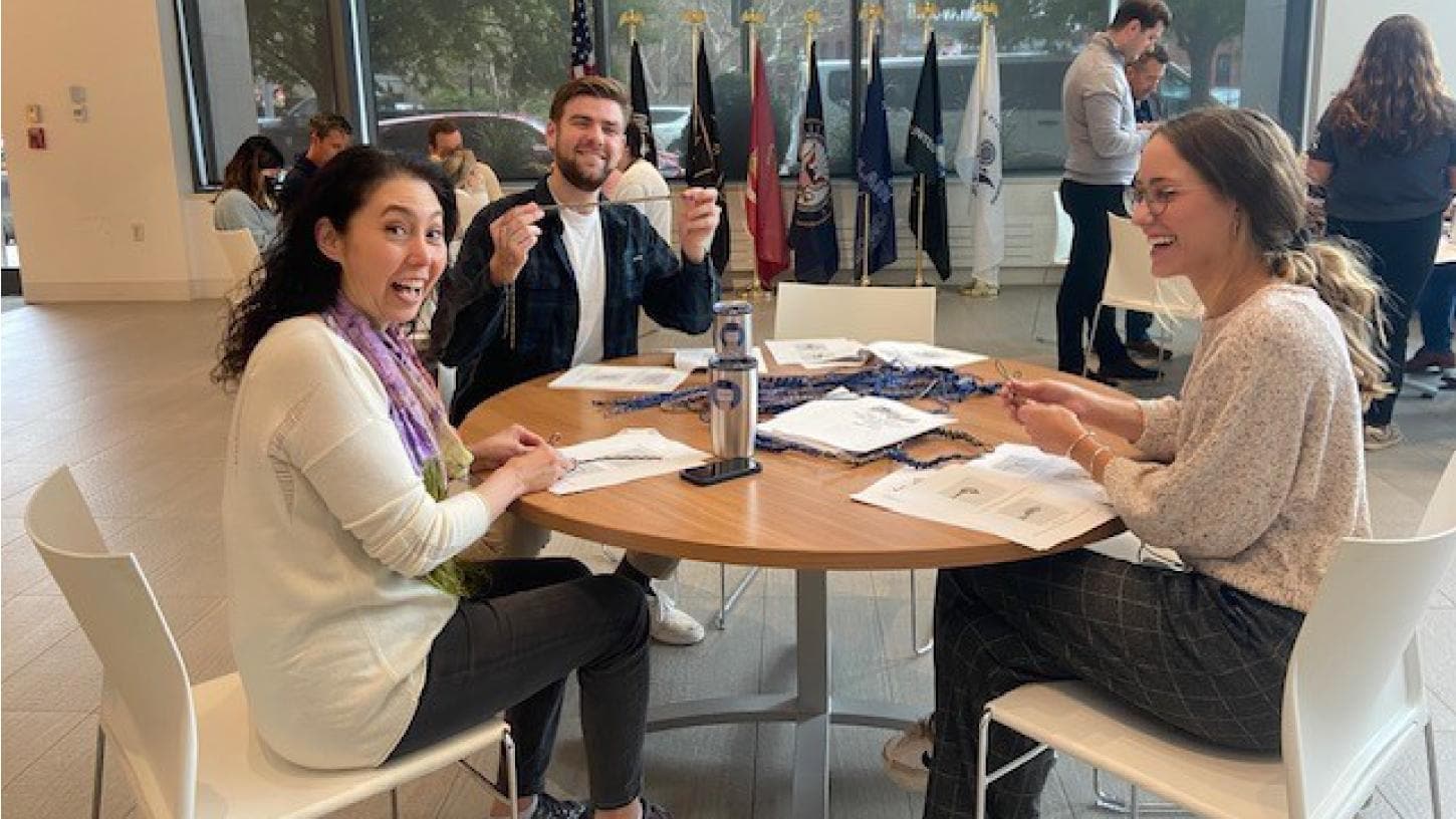 Three Liberty employees participating in ERG activities; sitting at  a table smiling and chatting