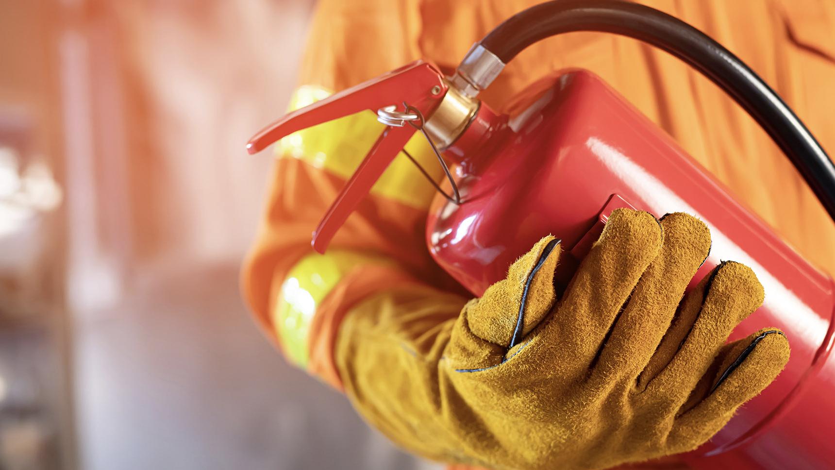 Closeup shot of a fireman holding an extinguisher 