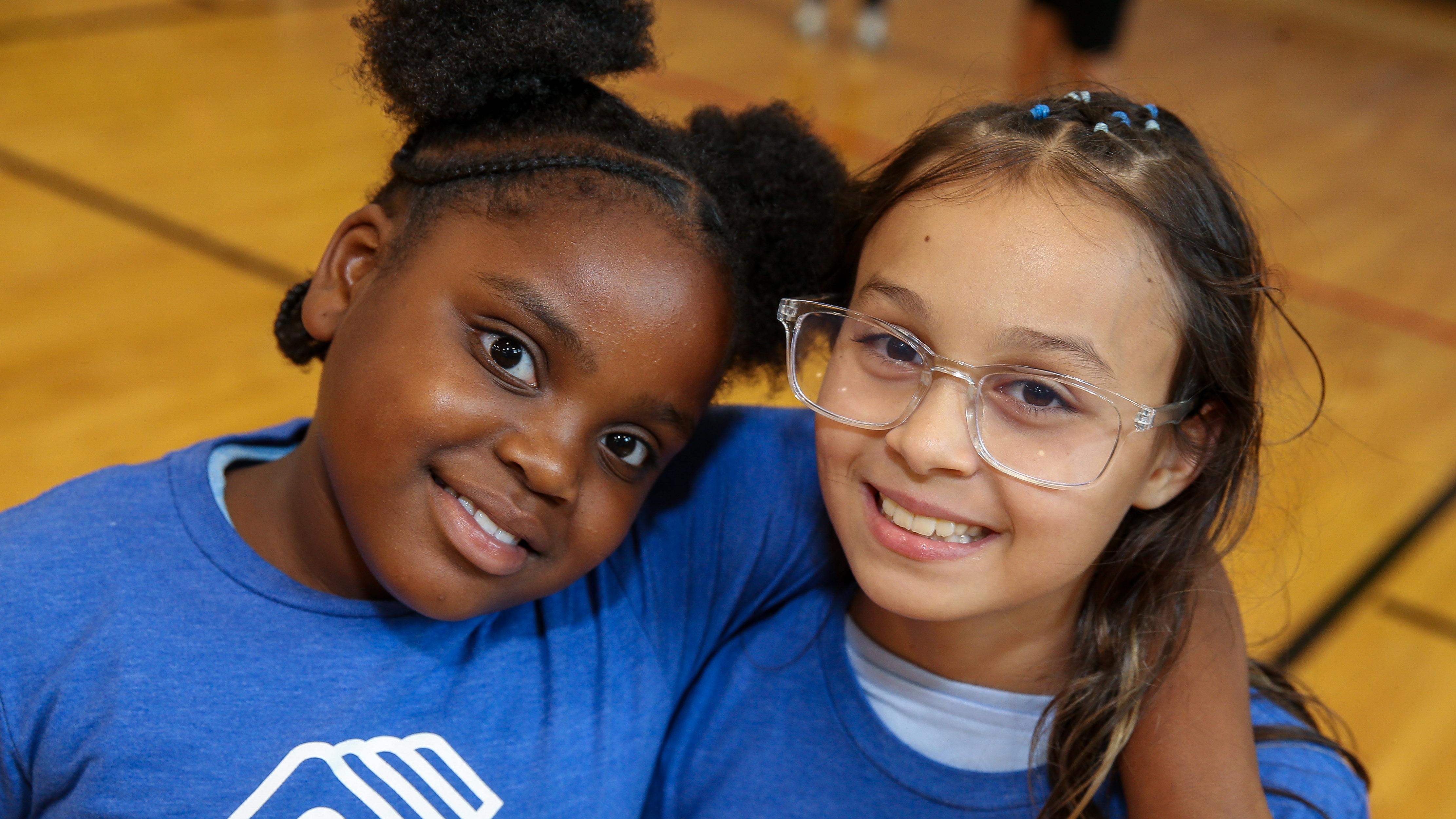 Two girls hugging and wearing Boys & Girls Club T-shirts