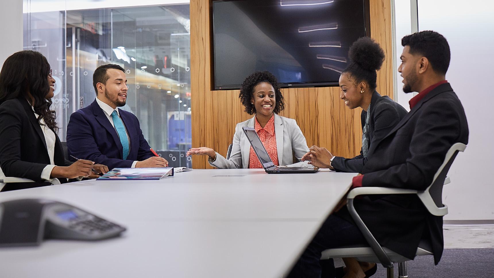 Year UP: A group of people meeting around a table in a conference room