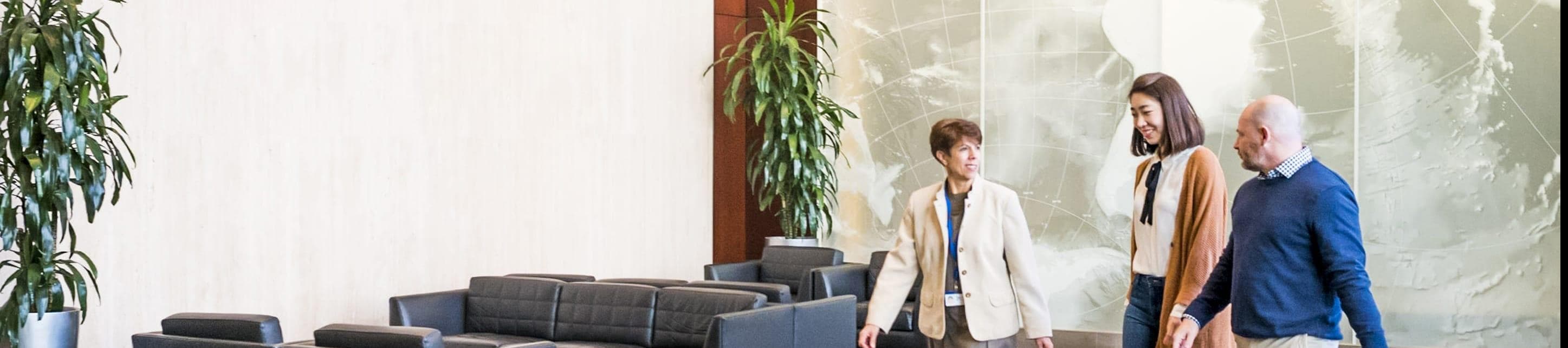 Three employees walking through a Liberty Mutual office entryway