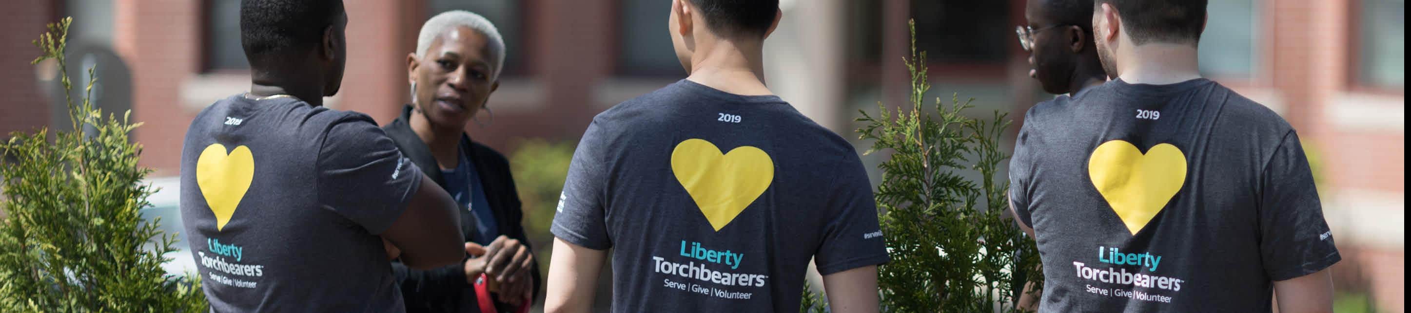 Group of Liberty Mutual Employees wearing Serve with Liberty shirts, talking