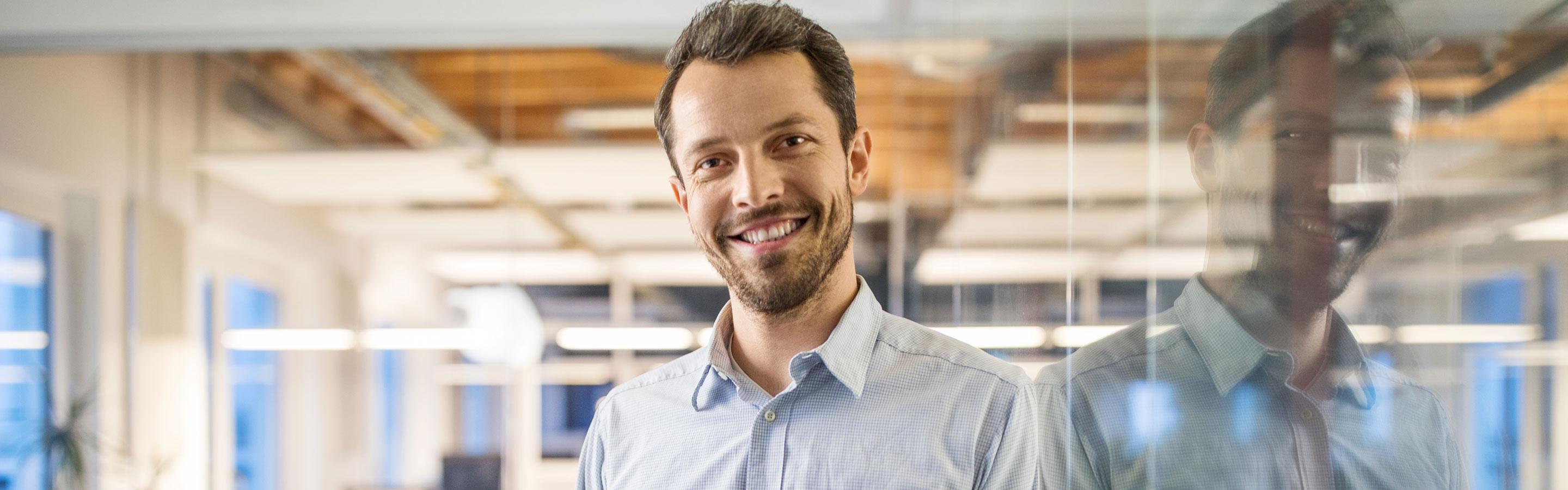 Male employee smiling to camera in a modern office design