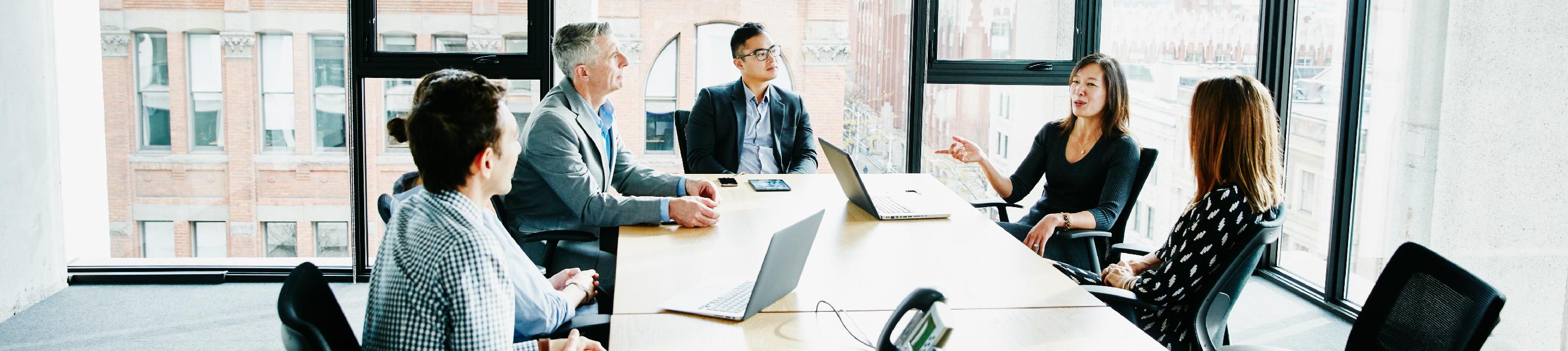 Group of people in a conference room chatting at a table