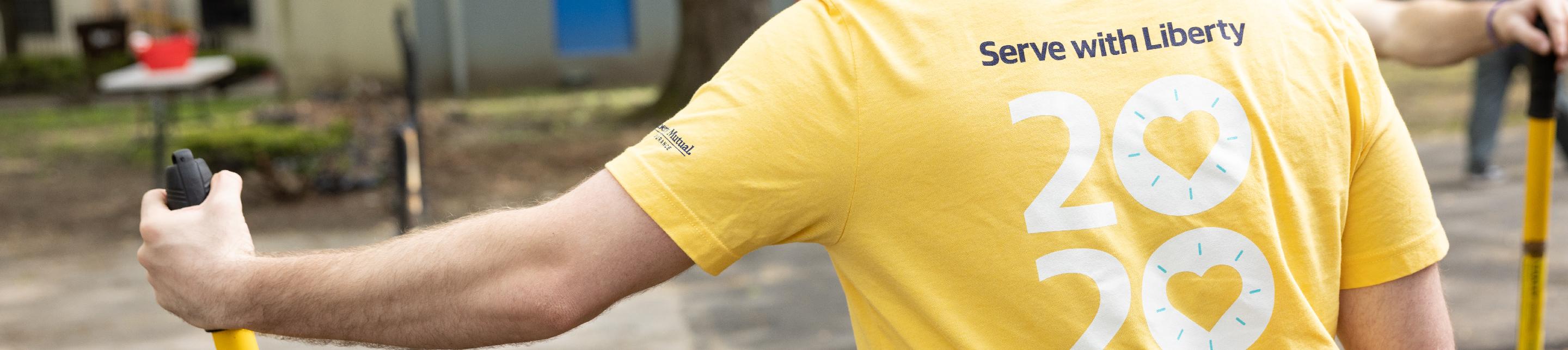Back of an LM employee wearing a Serve with Liberty shirt