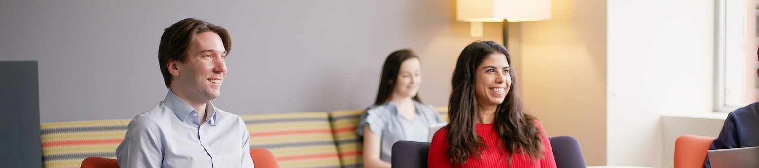 Group employees sitting and meeting; smiling